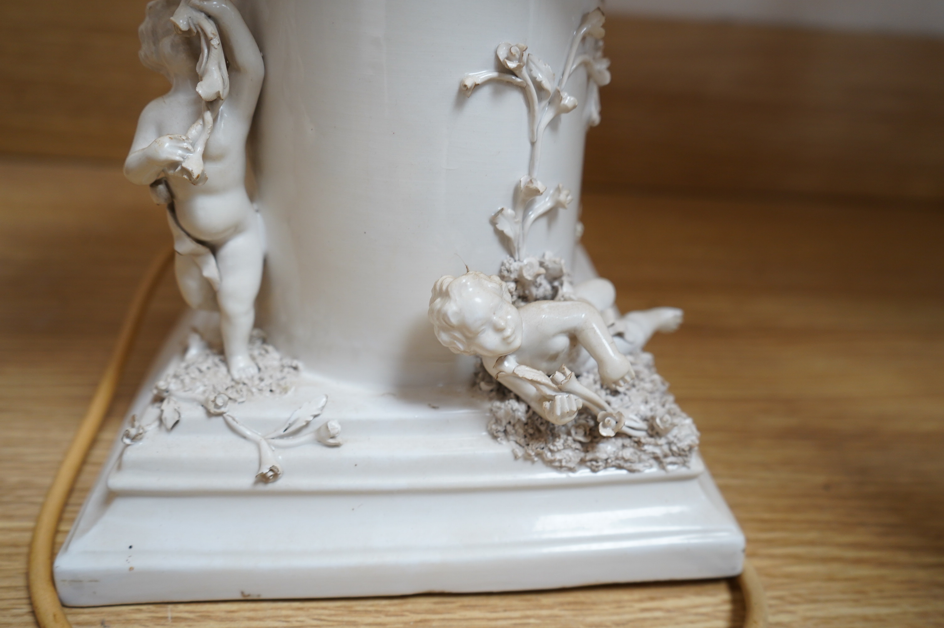 A modern Italian white maiolica ‘playing putti’ table lamp, 55cm. Condition - fair